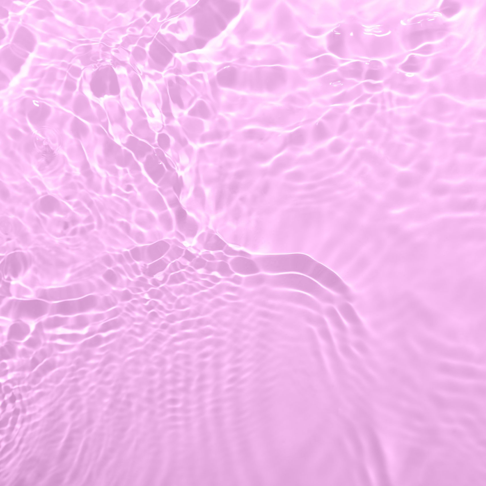 Closeup of pink transparent clear calm water surface texture with splashes and bubbles. Trendy abstract summer nature background. Wildberry colored waves in sunlight.